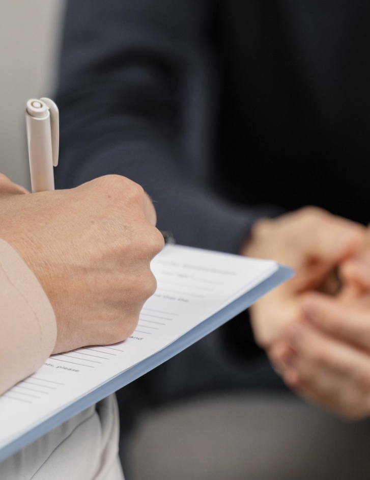 terapeuta-de-mujer-de-tiro-medio-tomando-notas-en-el-portapapeles